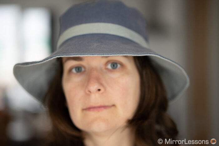 out of focus portrait of a woman wearing a summer hat