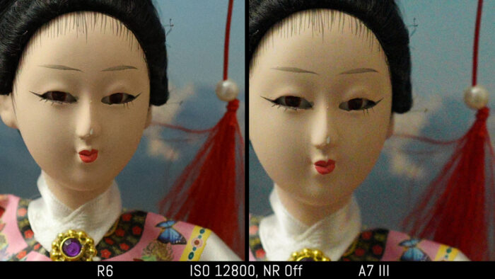crop of the japanese doll out of camera JPEG image to show the difference in noise at 12800 ISO with noise reduction set to Off