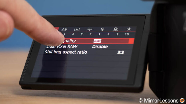 Finger touching the screen and changing a setting in the Canon menu